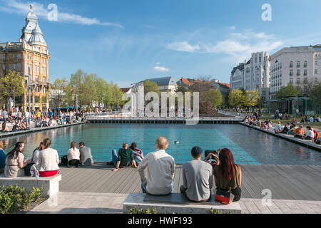 Im Frühling sitzen die Leute draußen am reflektierenden Pool im Erzsebet ter in Budapest Stockfoto