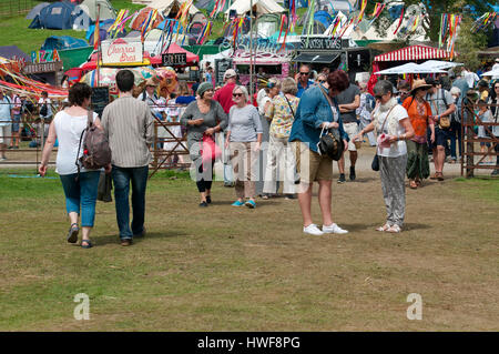 Massen und Familien zu Fuß durch die Anlage mit Zelten und Imbissbuden im Hintergrund der Hafen Eliot Festival Cornwall Stockfoto