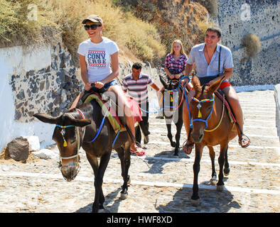 Familie Reiten Esel die Klippe vom alten Hafen der Stadt Fira auf Santorin auf den griechischen Inseln. Stockfoto