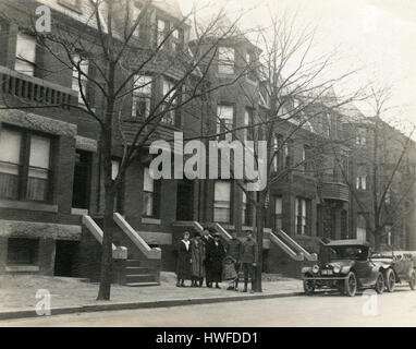 Antike c1918 Foto, Familie mit Chauffeure und ihre 1918 Buick mit New York Nummernschild, geparkt auf Straße vor Stadthäuser. Lage ist möglicherweise Brooklyn, New York. Alamy HWFDE3 für eine Alternative Ansicht des Bildes zu sehen. QUELLE: ORIGINAL FOTOABZUG. Stockfoto