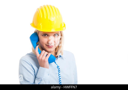 Ingenieurin mit Helm hält Telefonhörer und lächelnd isolierten auf weißen Hintergrund mit textfreiraum text Stockfoto