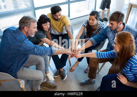 Kreative Business-Team setzen ihre Hände zusammen im Büro Stockfoto
