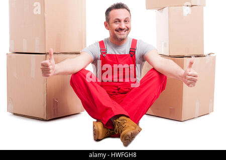 Mann, sitzen umgeben von Boxen, die zeigen, wie mit beiden Händen und lächelnd isoliert auf weißem Hintergrund Stockfoto