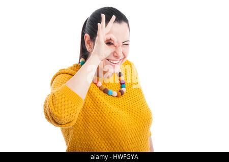 Schöne Brünette zeigt ok Zeichen vor ihren Augen und lächelte, isoliert auf weiss mit Exemplar Stockfoto