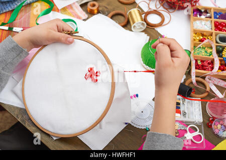 Junge auf Reifen, Hand Closeup und rotes Band auf weißen Textilien bestickt erfährt, Nähen, job, Ausbildung, Handarbeit und Kunsthandwerk-Konzept Stockfoto