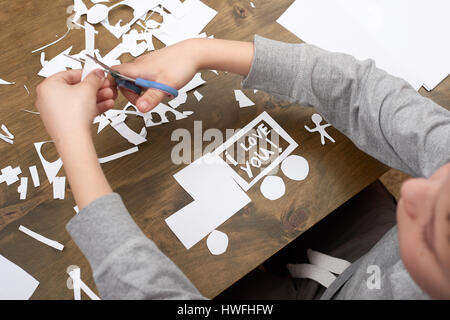 junge macht Origami - Auto und Familie, Kinder, Eltern, ich liebe dich Text, Draufsicht auf Holz Hintergrund Stockfoto