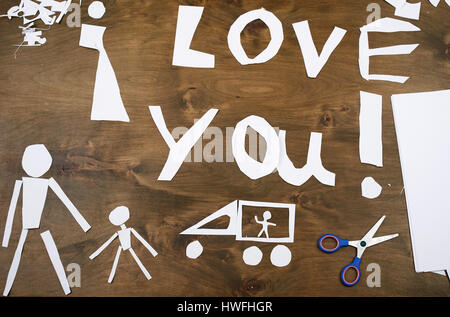 junge macht Origami - Auto und Familie, Kinder, Eltern, ich liebe dich Text, Draufsicht auf Holz Hintergrund Stockfoto