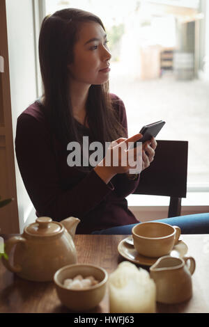 Schöne Frau mit Handy in CafÃƒÂ © Stockfoto