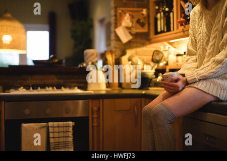 Porträt der Frau hält eine Kaffeetasse in der Küche zu Hause Stockfoto