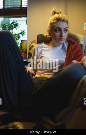 Frau sitzt auf der Couch im Wohnzimmer zu Hause Stockfoto
