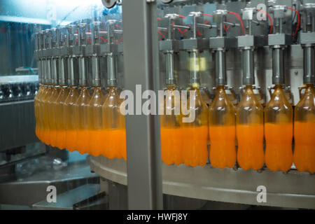 Flaschen gefüllt mit Saft auf Produktionslinie im Werk Stockfoto
