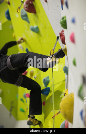 Menschen Sie üben Klettern an künstlichen Kletterwand im Fitness-Studio Stockfoto