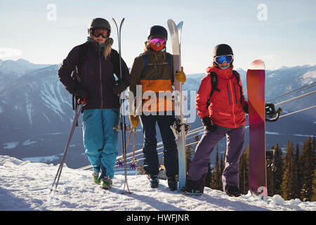 Drei Skifahrer mit Himmel stehend auf verschneite Landschaft im Skigebiet Stockfoto