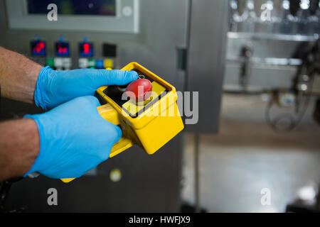 Hand des Arbeiters mit gelben Maschinen in der Fabrik zugeschnitten Stockfoto