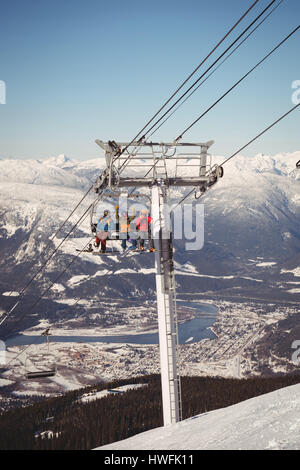 Niedrigen Winkel Blick auf drei Skifahrer unterwegs in Skilift am Skigebiet Stockfoto