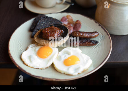 Teller mit englisches Frühstück mit Eiern und Würstchen auf Tisch Stockfoto