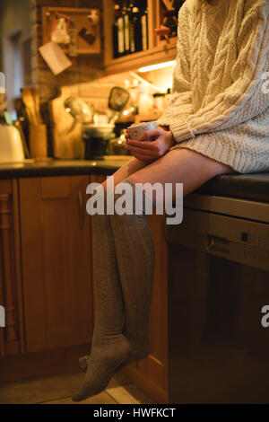 Porträt der Frau hält eine Kaffeetasse in der Küche zu Hause Stockfoto