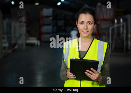 Porträt der schönen jungen Frau, die mit digital-Tablette in Fabrik Stockfoto