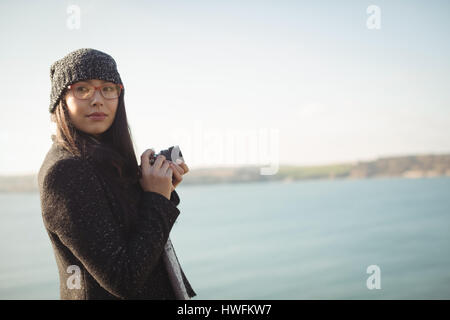 Schöne Frau mit einer digitalen Kamera in der Nähe von See im park Stockfoto