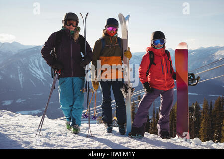 Drei Skifahrer mit Himmel stehend auf verschneite Landschaft im Skigebiet Stockfoto