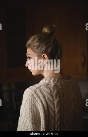 Nachdenkliche Frau in der Küche zu Hause Stockfoto