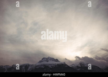 Malerische Aussicht auf schneebedeckte Berge gegen bewölktem Himmel Stockfoto