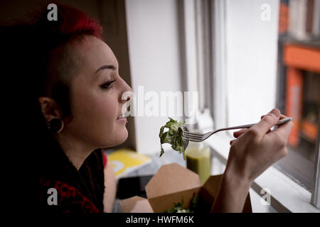 Schöne Frau mit einem Salat in CafÃƒÂ © Stockfoto