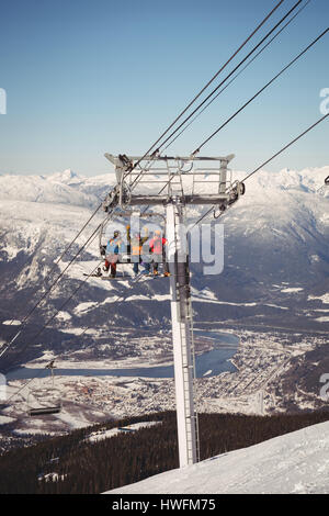 Niedrigen Winkel Blick auf drei Skifahrer unterwegs in Skilift am Skigebiet Stockfoto