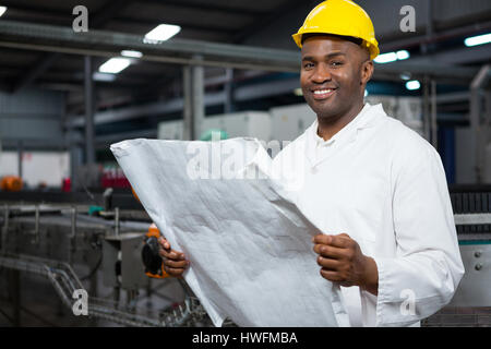 Porträt des Lächelns männlichen Arbeitnehmer Lesung Anweisungen werkseitig Saft Stockfoto