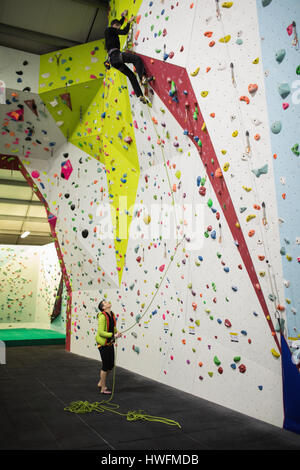Menschen Sie üben Klettern an künstlichen Kletterwand im Fitness-Studio Stockfoto