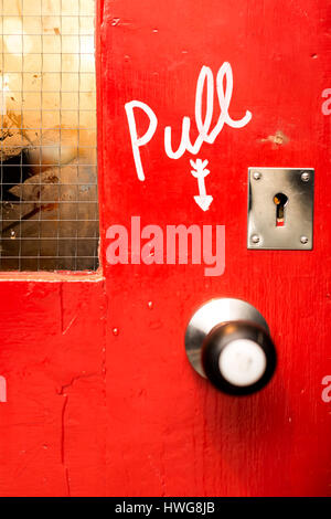 Rote Tür mit bemalten ziehen Zeichen in Cambridge Stockfoto