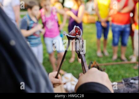 Schmied macht eine geschmiedete Rose aus Metall Stockfoto