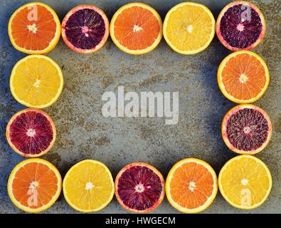 Bunte Orangen, Blutorangen und Cara Cara Orangen halbieren auf einem Stein Hintergrund Stockfoto