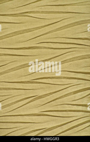 Gelb-goldene zerknittert synthetische Textilien, zerknittert Polyester Stoff Detail, vertikale dekorative faltig Texturmuster, helle große detaillierte Textur Stockfoto