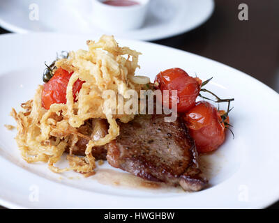 Mittags Steak Tomate auf der Rebe und gewellten Pommes Stockfoto