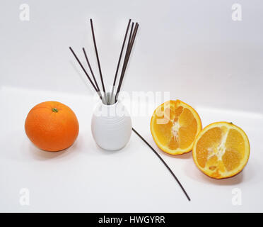 Aromatische sticks für Haus in weißer Keramik-Vase mit Früchten. Isoliert auf weiss Stockfoto