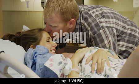 Höhenplan der neuen Mutter und Vater bewundernden neugeborenes Baby im Krankenhaus Stockfoto