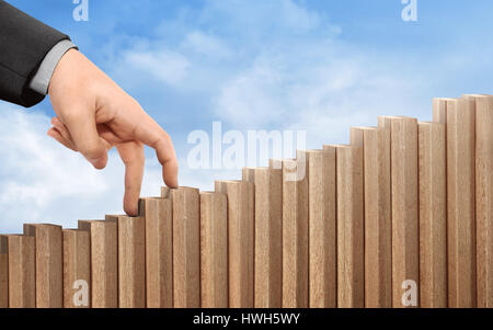 Unternehmen der Hand Wandern auf Holztreppen mit Himmel im Hintergrund Stockfoto