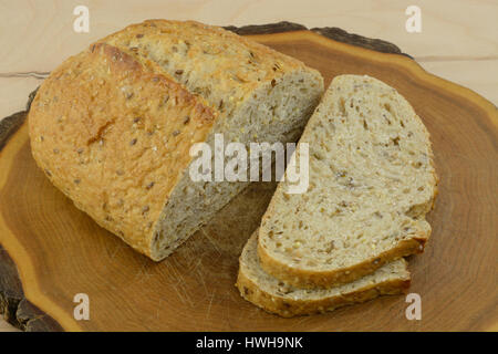 Laib und Scheiben von neun Korn Vollkornbrot auf Holz Schneidebrett Stockfoto