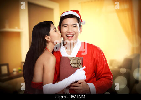 Weihnachtsfrau Kuß an ihren Geliebten. Weihnachten-Konzept Stockfoto