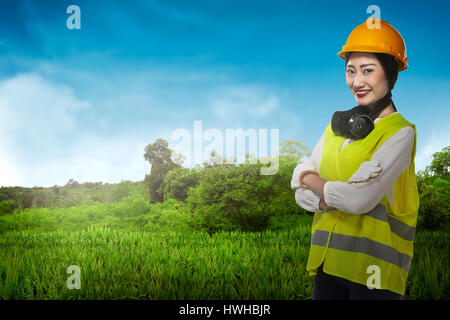 Asiatische Geschäftsfrau mit gelben Helm Lächeln über Bau-Seiten-Hintergrund Stockfoto