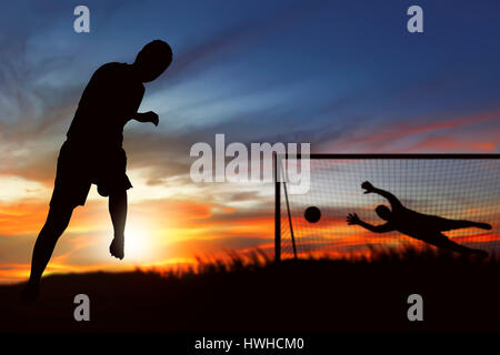 Silhouette des Fußball-Spieler auf dem Feld Strafstoss ausgeführt Stockfoto