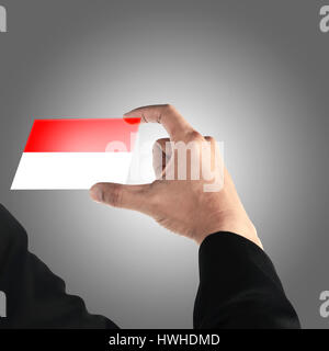 Hand des Menschen halten indonesische Flagge in transparente Karte Stockfoto