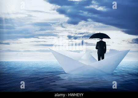 Asian Business Mann mit Regenschirm stehen auf dem Papier, Boot, Segeln auf dem Ozean Stockfoto