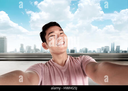 Gut aussehender Mann tun Selfie mit Stadtbild Hintergrund Stockfoto