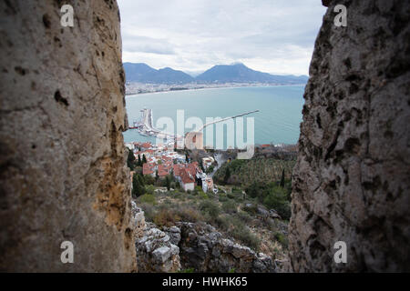 Blick auf Alanya mediterrane Stadt der Türkei zwischen den Mauern der Burg zeigt Meer berge Roter Turm Schuß auf düsteren Tag Stockfoto