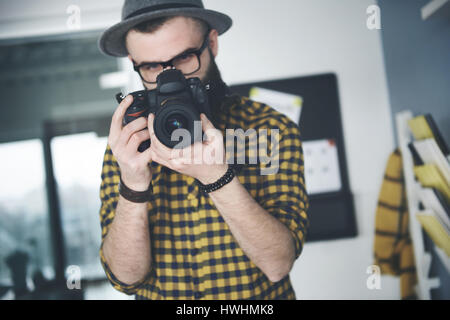 Männliche Fotograf, die Bearbeitung der Bilder vor der Kamera Stockfoto