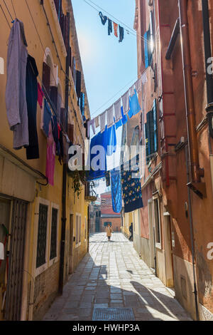 Venedig, Italien - 27. Februar 2017: typische Gasse mit Wäscheleinen und unbekannten Menschen. Venedig ist weltweit bekannt für die Schönheit seiner Einstellungen, ein p Stockfoto