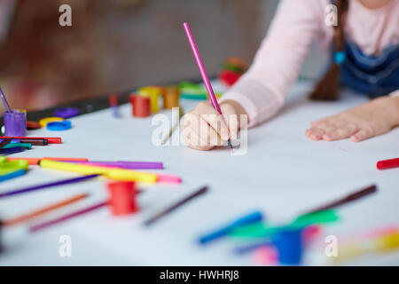 Kleines Mädchen hält Stift oder Marker auf Papier Stockfoto