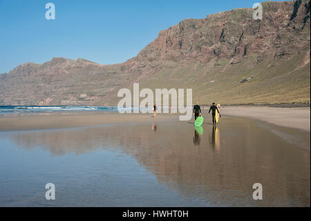 Reisen, Kanaren, Kanarische Inseln, Lanzarote: Surfer bin Playa de Famara. Stockfoto